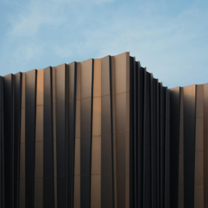 Sleek modern building facade with unique design set against a clear blue sky.